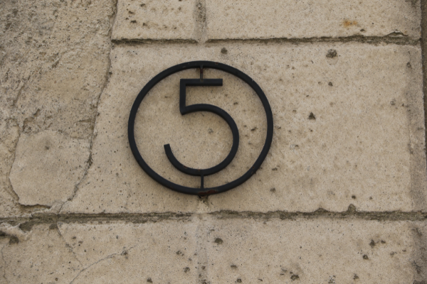 Metal number 5 on a brick wall